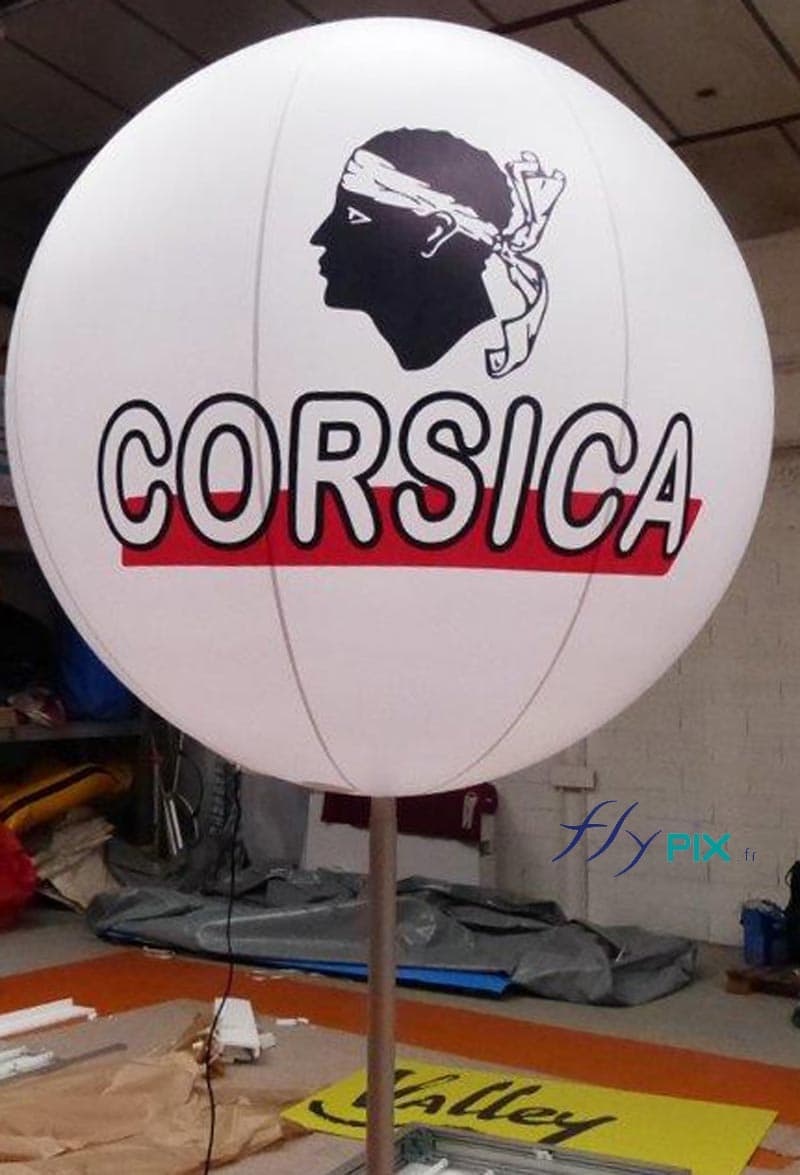 Vue plus détaillée du ballon sur mat éclairant et imprimé fabriqué pour CORSICA: impression en couleur sur 2 faces, sur fond blanc.