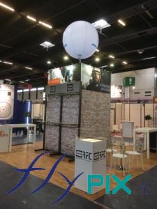 Un ballon sur mat imprimé, de forme sphérique, installé et déployé pour un stand dans un salon professionnel en environnement intérieur.